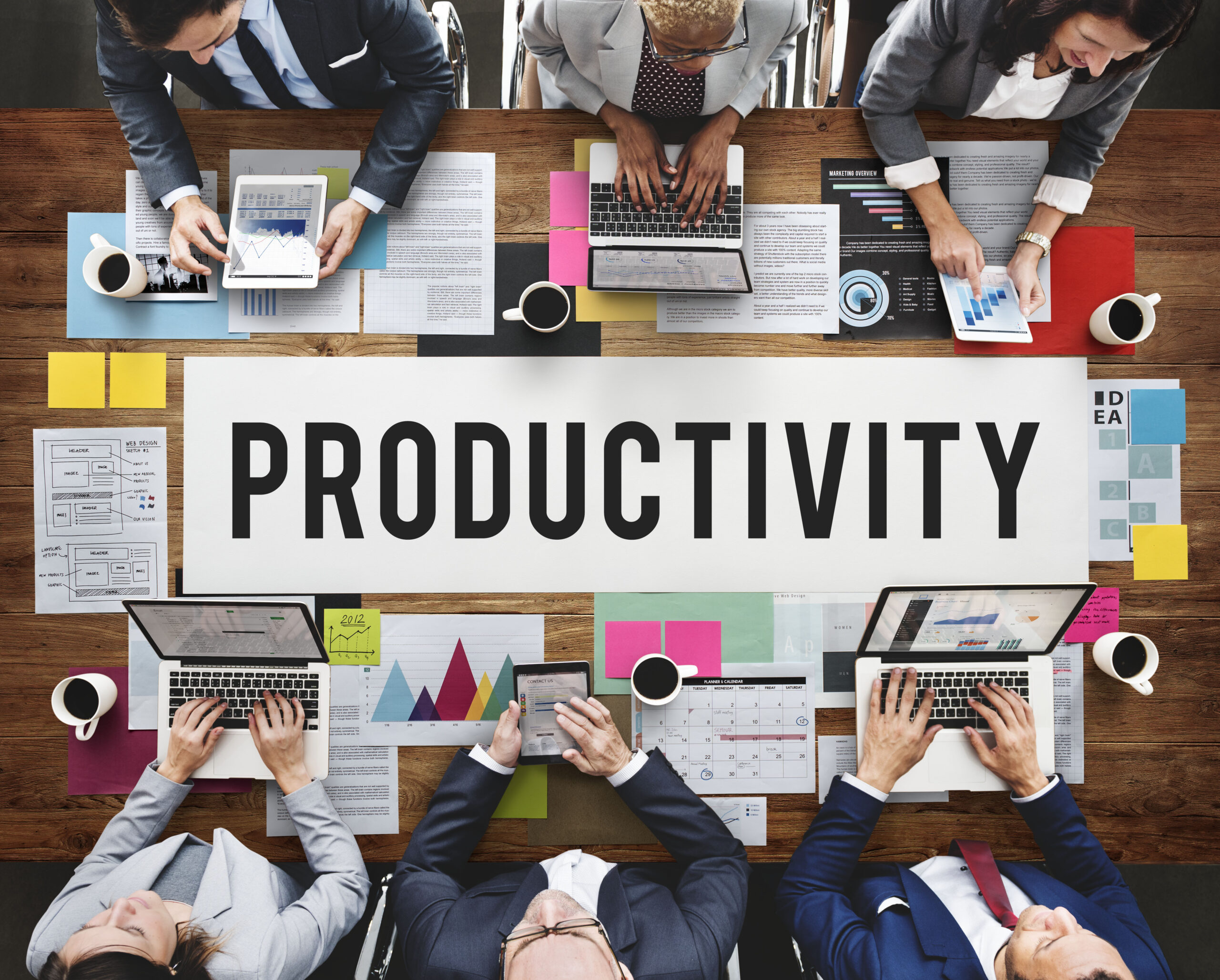Business professionals collaborating around a conference table can increase productivity with proactive IT support.