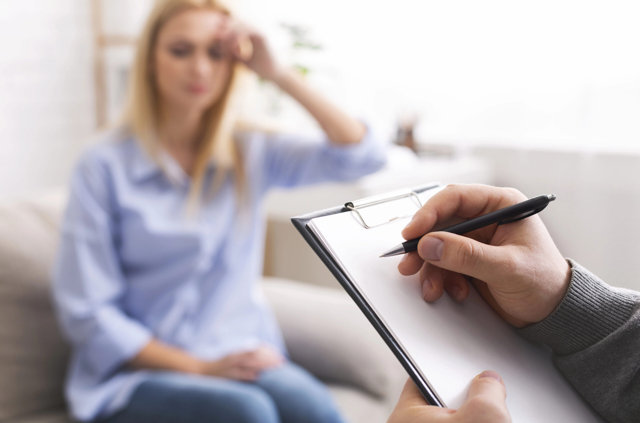 a therapist working with a clipboard showing the correlation between mental health and IT compliance checklists.
